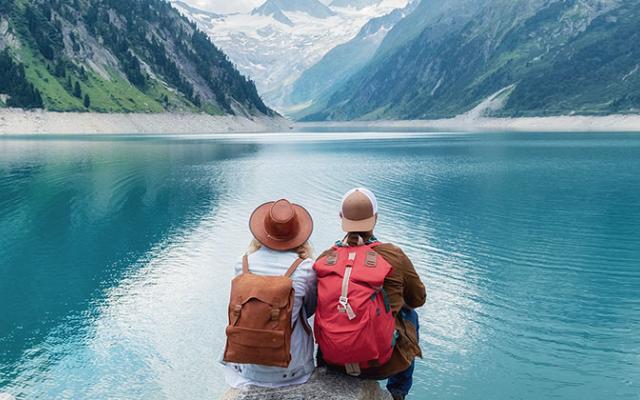 Dos personas sentadas frente a un lago