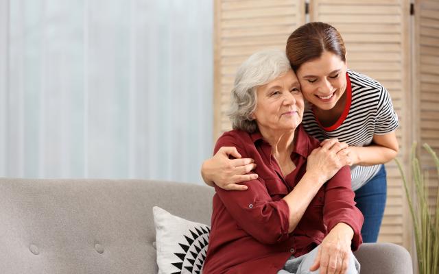 Mujer abrazada a su madre con Alzheimer.